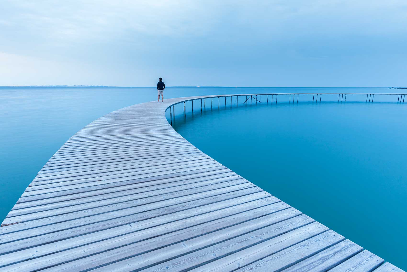 Geschwungener Steg im Meer steht für Stressbewältigung & Stressabbau durch Coaching